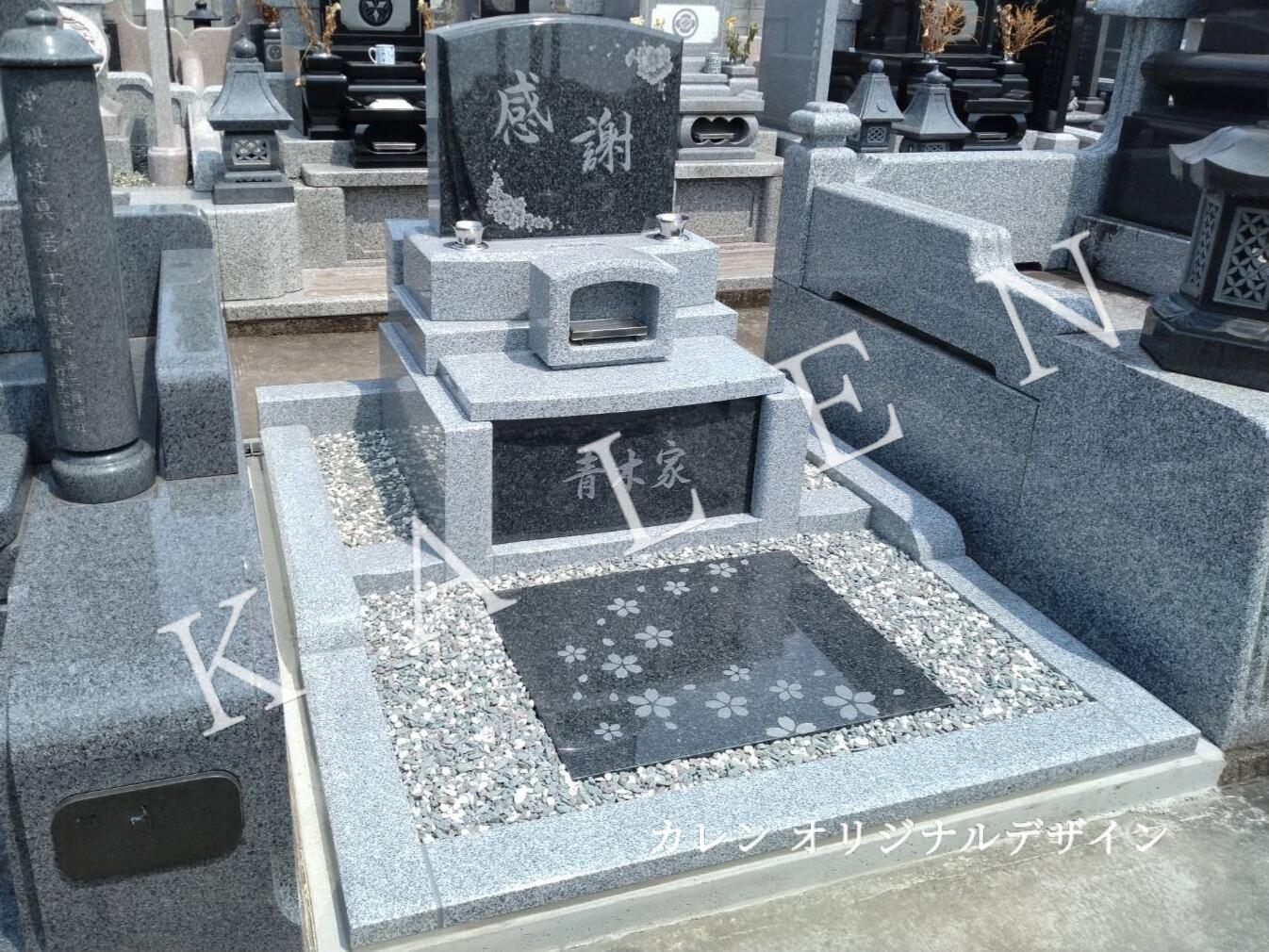 敷石に桜の流れる彫刻が刻まれた洋風墓石（墓石のカレン施工）