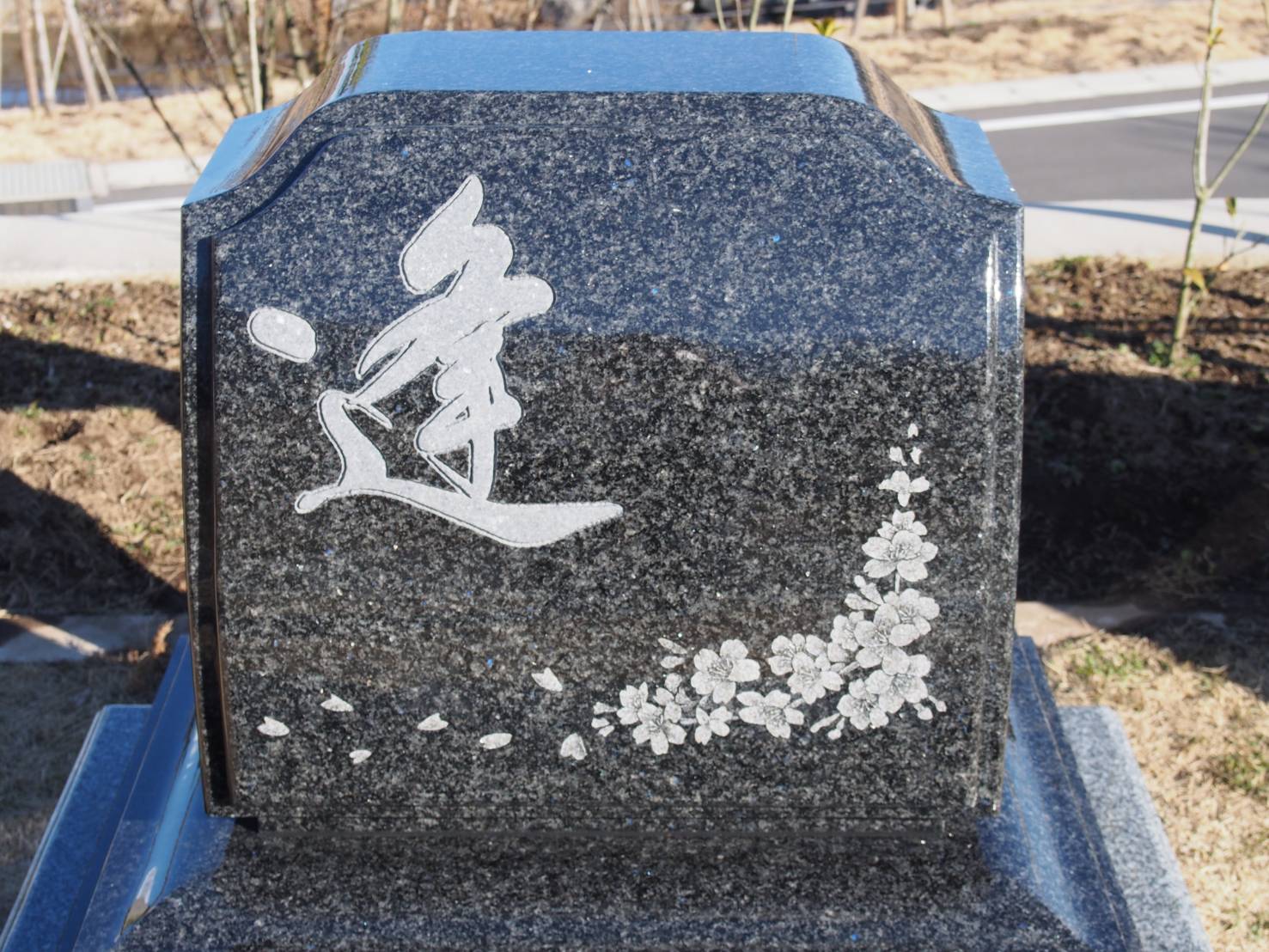 洋風のお墓に桜の花のイラストが影彫りされている