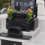 お墓の石塔とカロートのふたにゆりの花が彫刻されている