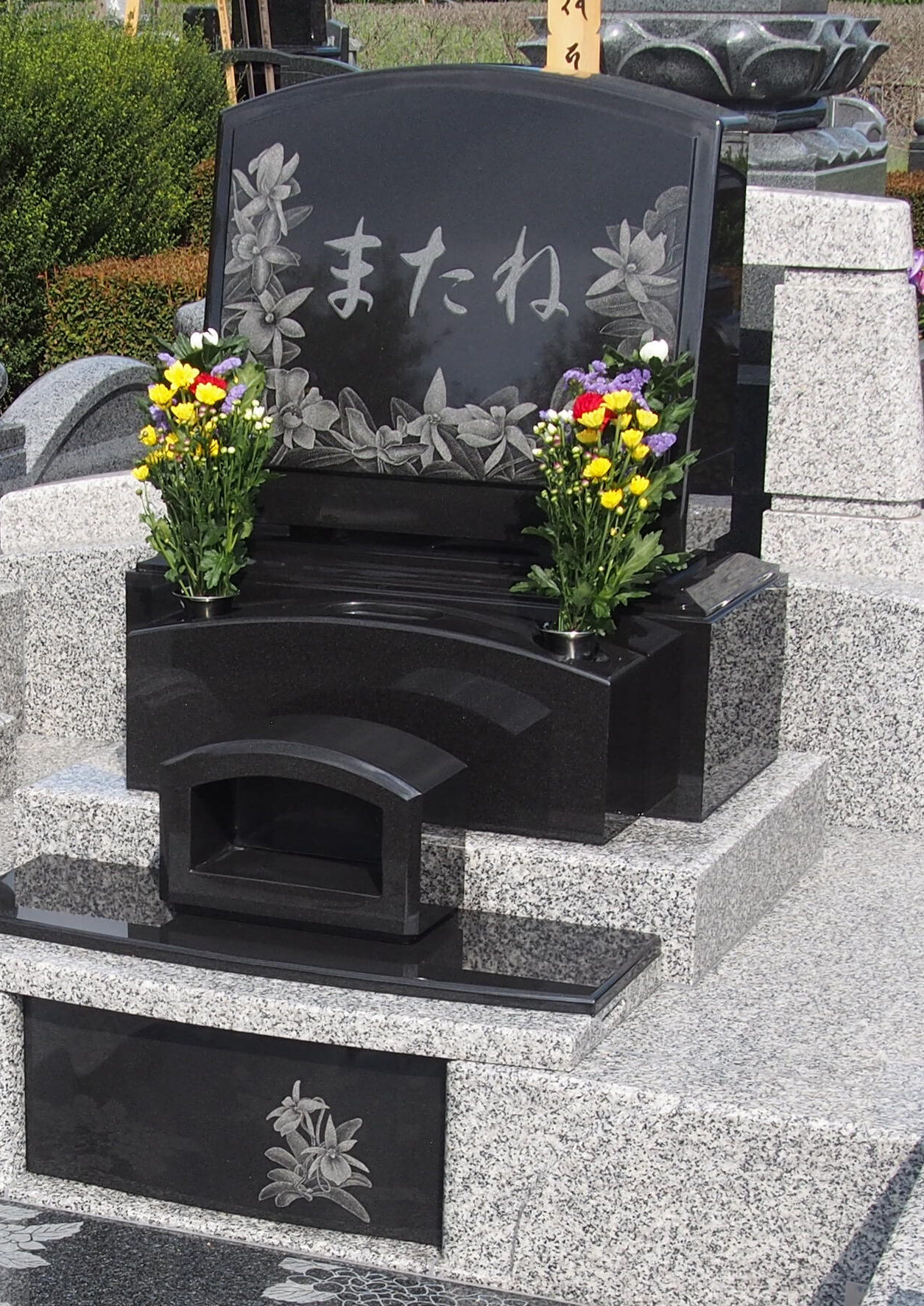 お墓の石塔とカロートのふたにゆりの花が彫刻されている