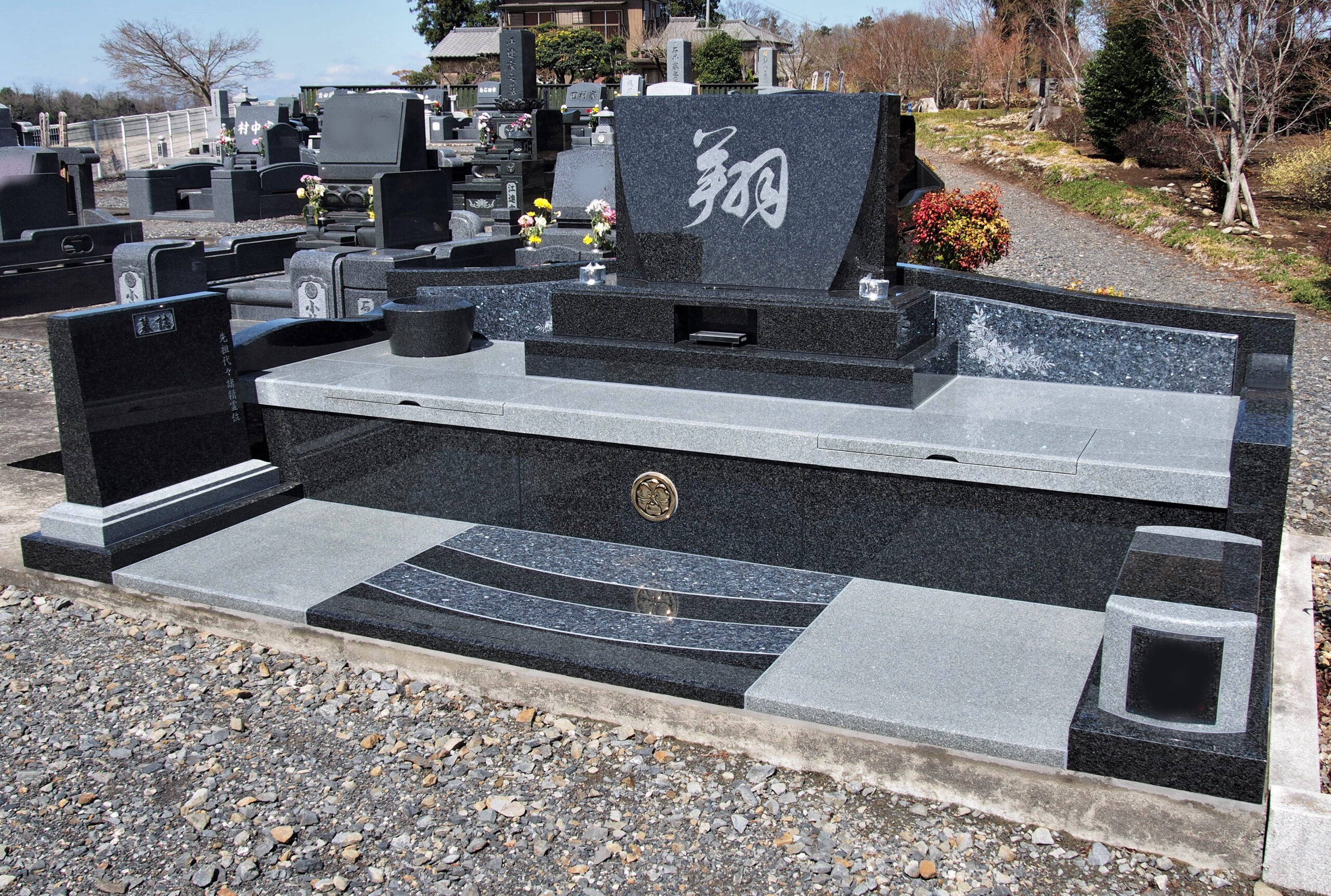 「翔」の文字が刻まれた石塔にブルーの石材を組み合わせたデザイン墓石（栃木県小山市）